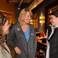 Two alumni smile with Lisa Knapp